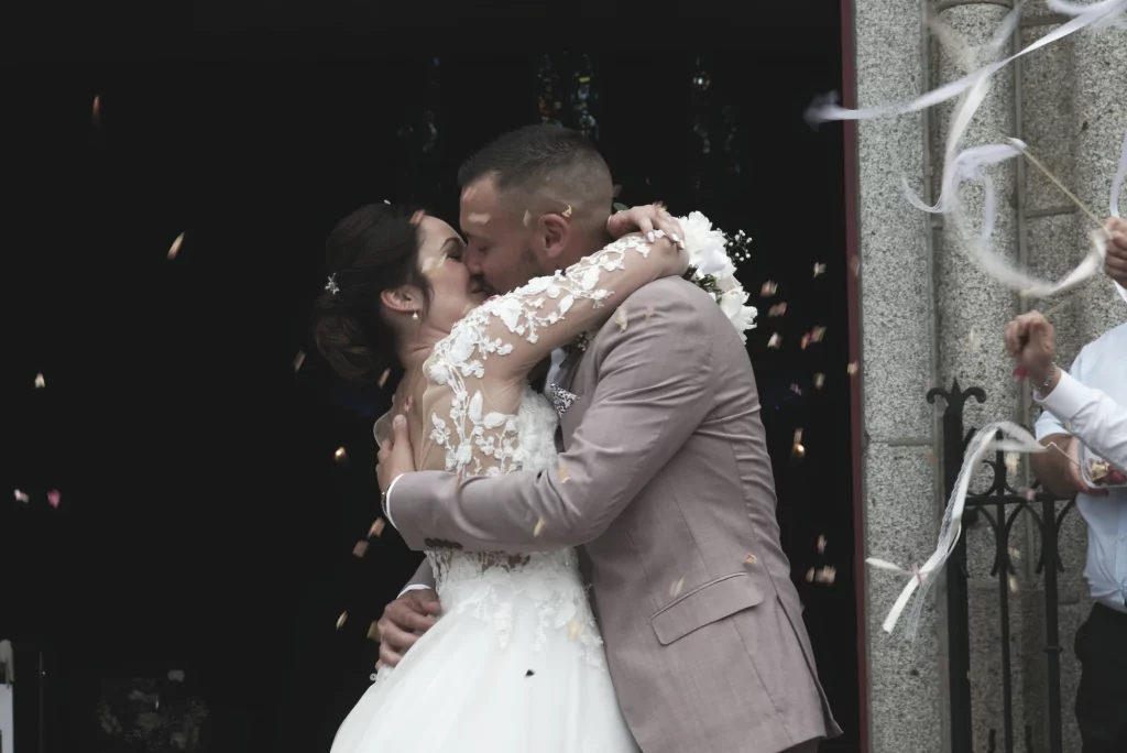 Baiser des mariés sous une pluie de confettis à Saint-Hilaire-du-Harcouët en Normandie.