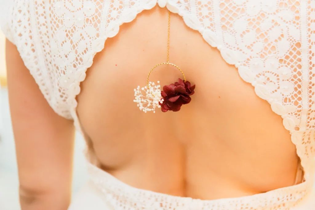 Bijou de dos fleuri sur une robe de mariée en dentelle blanche, mariage en Normandie.