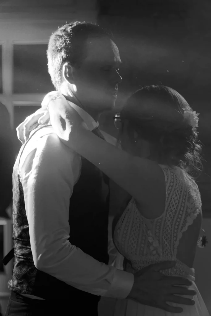 Couple de mariés dansant en noir et blanc, contre-jour dramatique, Saint-Hilaire-du-Harcouët, Normandie.