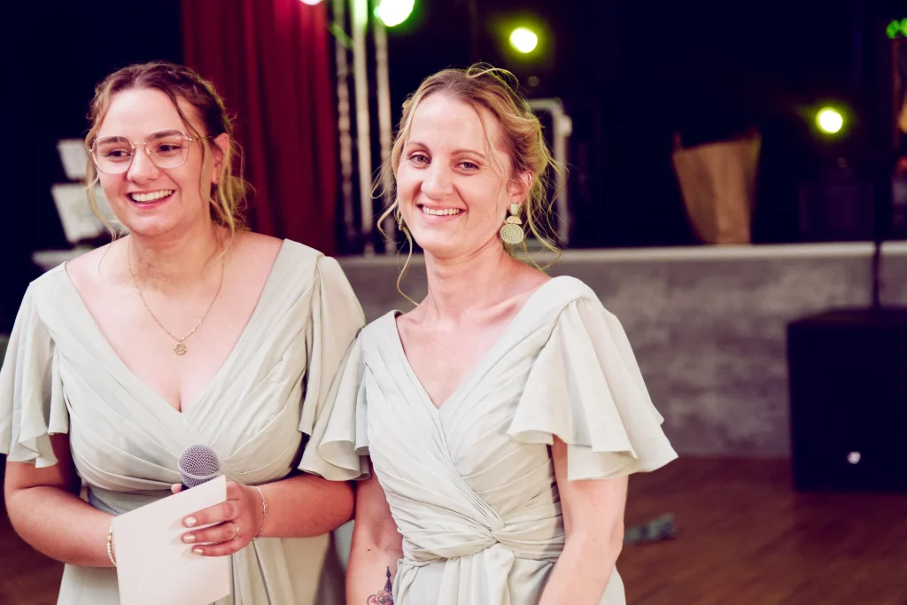 Deux demoiselles d'honneur en robe vert sauge lors d'un discours de mariage en Normandie.