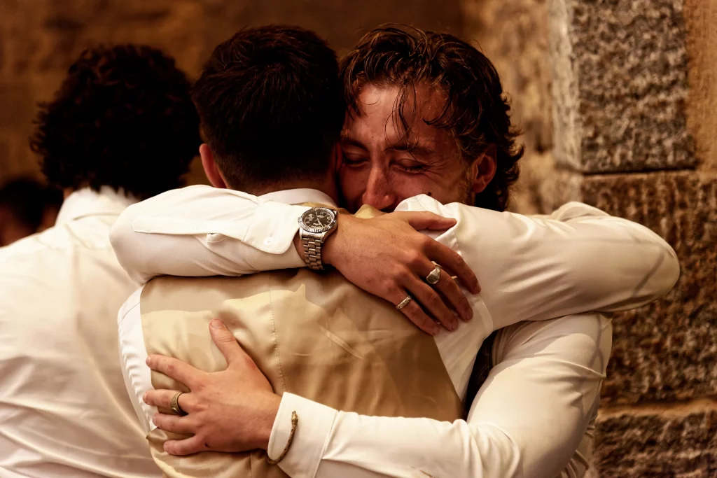 Étreinte entre deux hommes lors d'un mariage en Normandie, Saint-Hilaire-du-Harcouët.