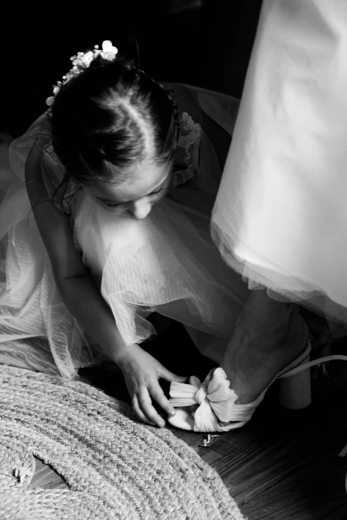 Fillette aidant la mariée avec ses chaussures à Saint-Hilaire-du-Harcouët, Normandie.
