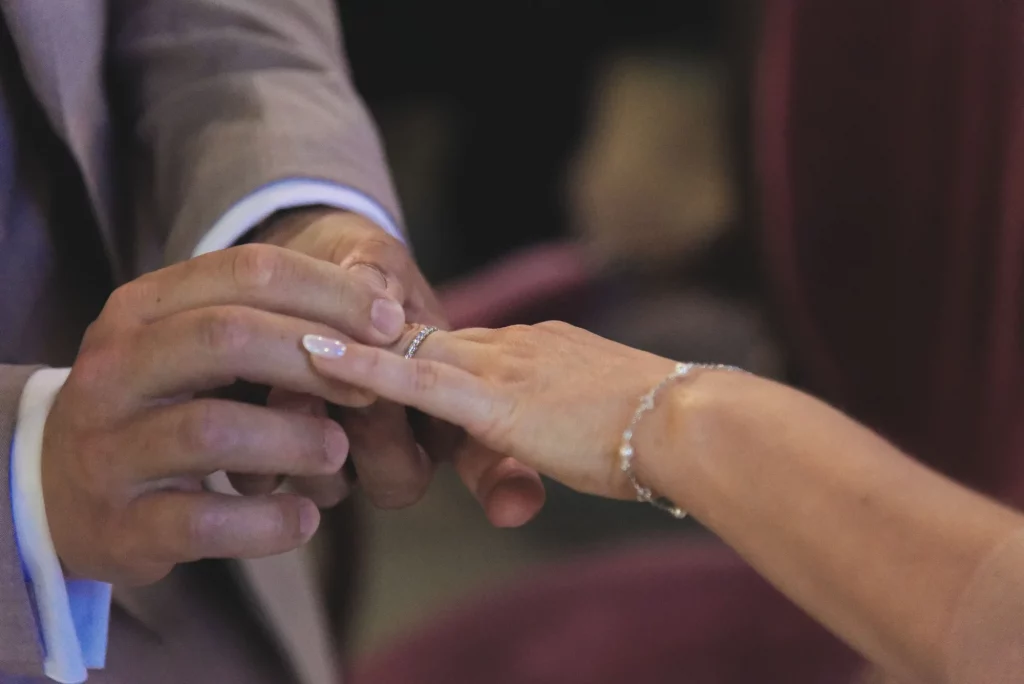 Gros plan d'un marié mettant la bague au doigt de la mariée lors d'un mariage à Saint-Hilaire-du-Harcouët.