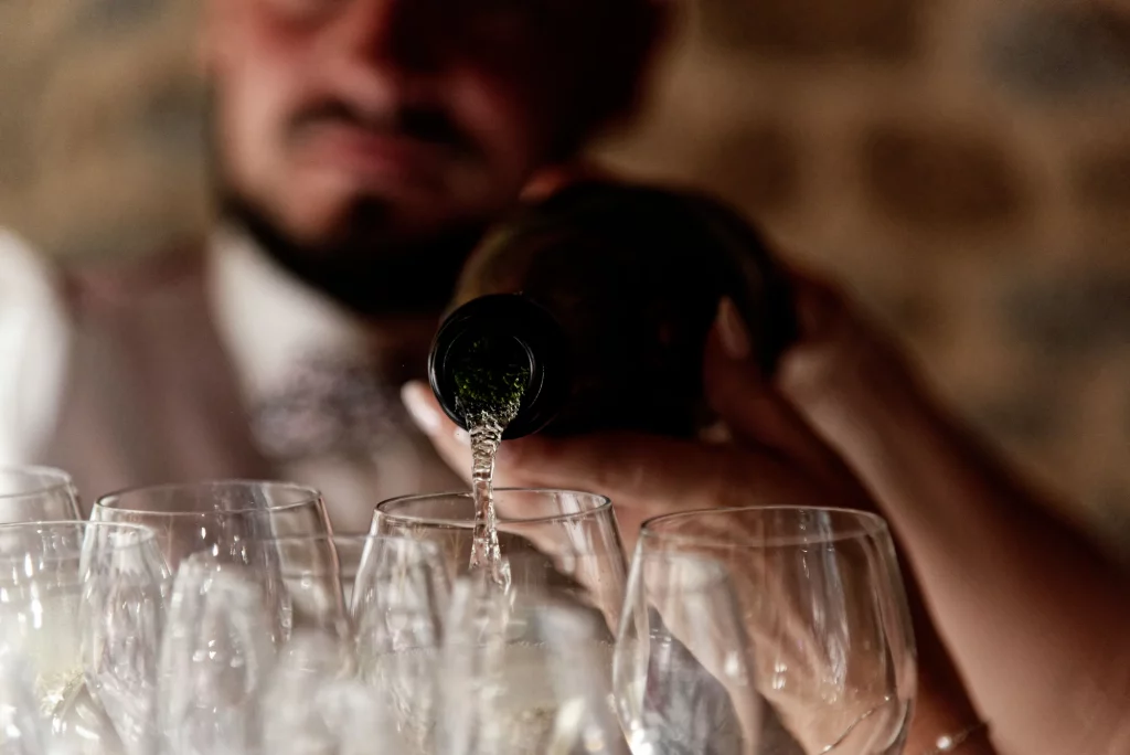 Gros plan cinématographique sur le champagne versé dans les coupes.