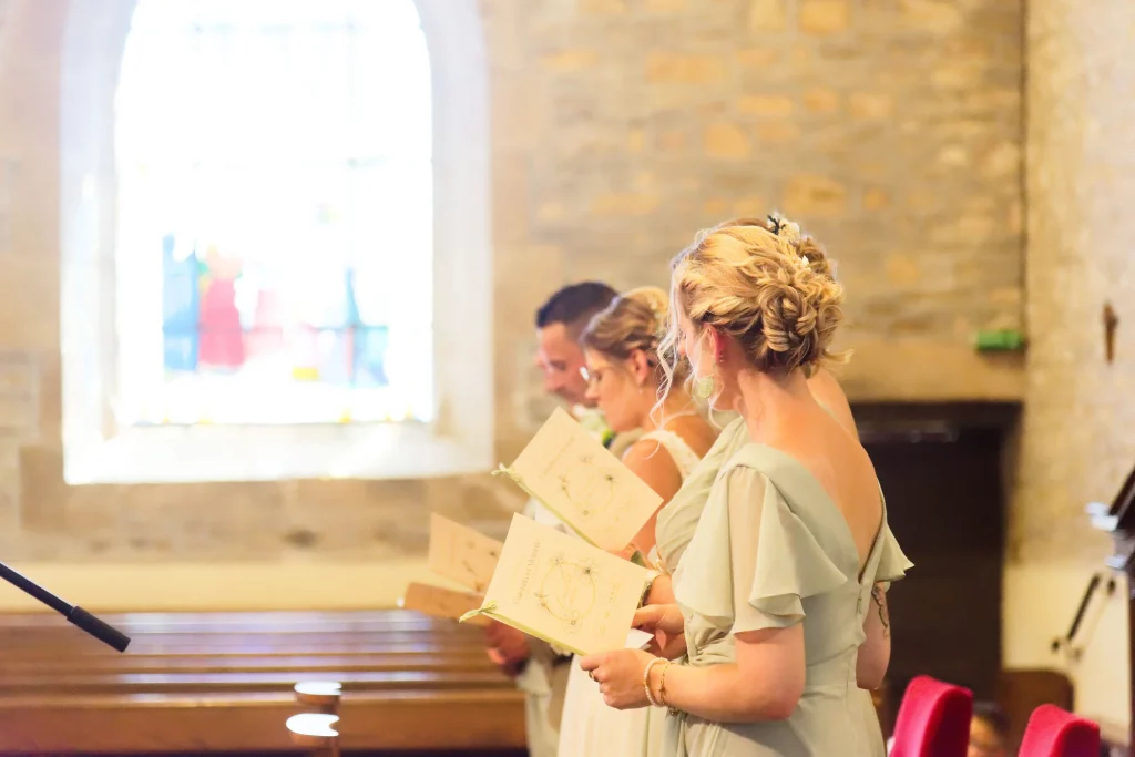 Invitées lisant le livret de messe lors d'un mariage à Saint-Hilaire-du-Harcouët en Normandie.