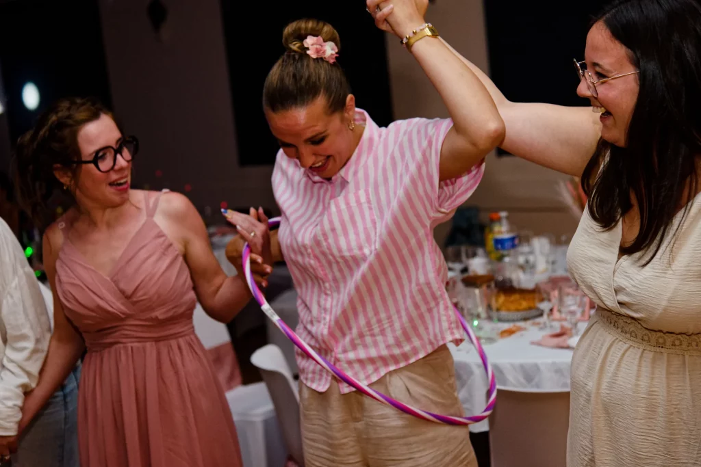 Invitées riant et faisant du hula-hoop lors d'un mariage à Saint-Hilaire-du-Harcouët en Normandie.