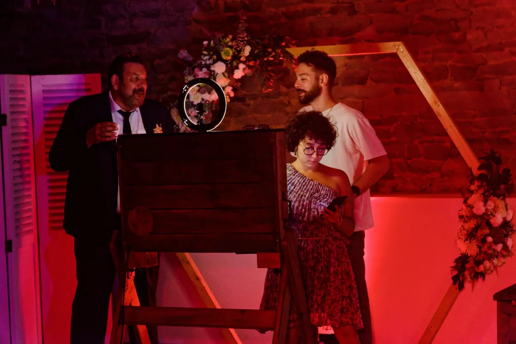 Invités autour d'un photobooth en bois, mariage à Saint-Hilaire-du-Harcouët, Normandie.