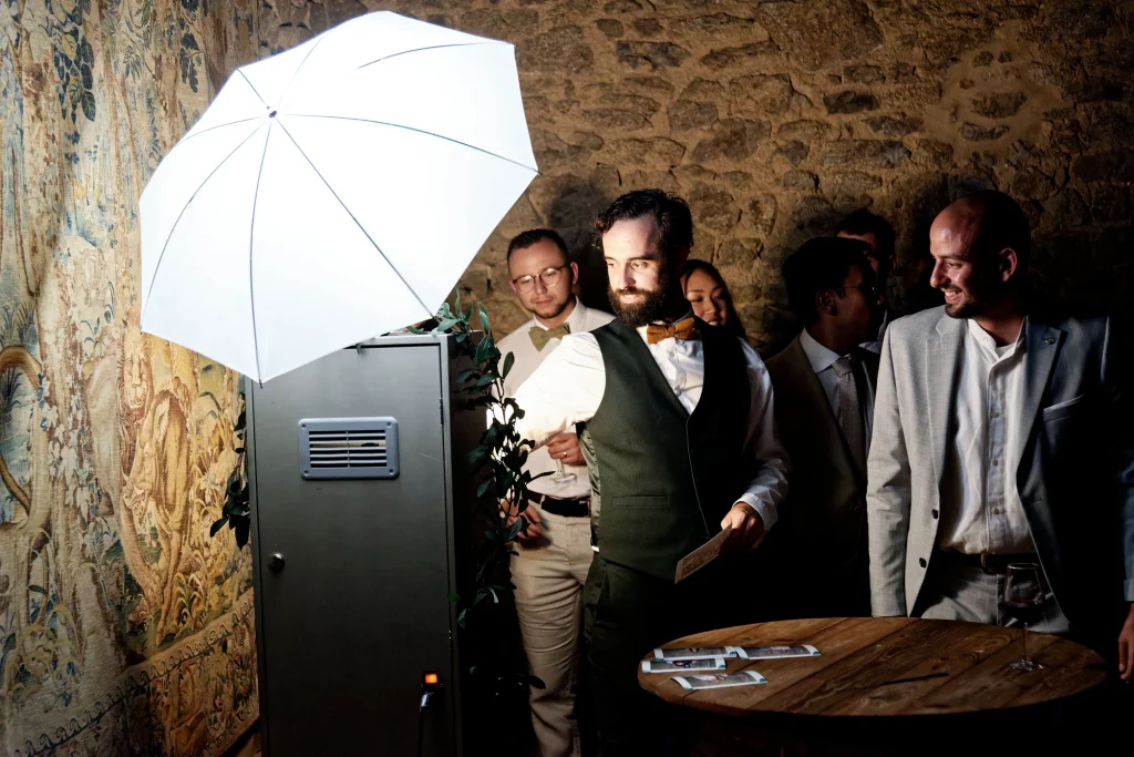 Invités de mariage découvrant leurs photos devant un photobooth en Normandie.