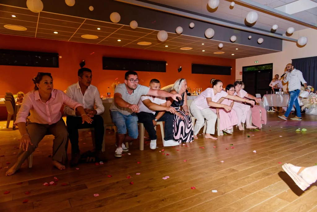 Invités de mariage tendant les bras lors d'un jeu à Saint-Hilaire-du-Harcouët en Normandie.