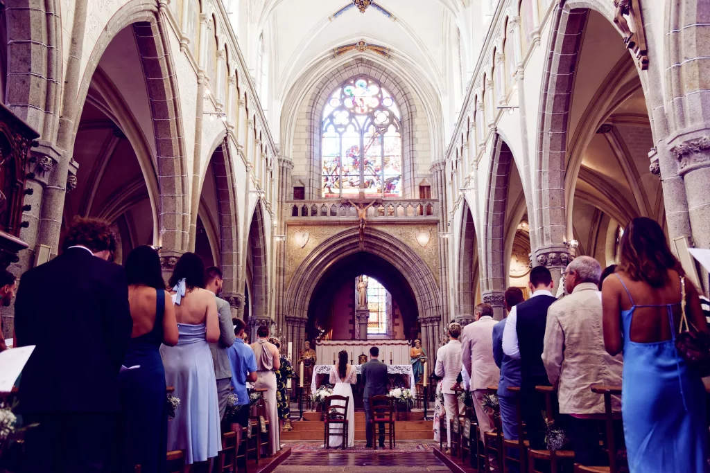 Mariage à l'église Saint-Hilaire-du-Harcouët, mariés à l'autel entourés de leurs invités en Normandie.