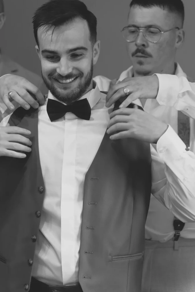 Marié souriant aidé par ses proches à Saint-Hilaire-du-Harcouët en Normandie.