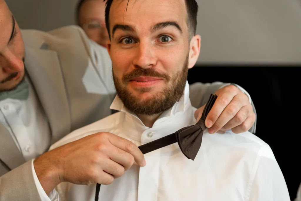 Marié surpris lors de l'ajustement de son nœud papillon marron à Saint-Hilaire-du-Harcouët en Normandie.