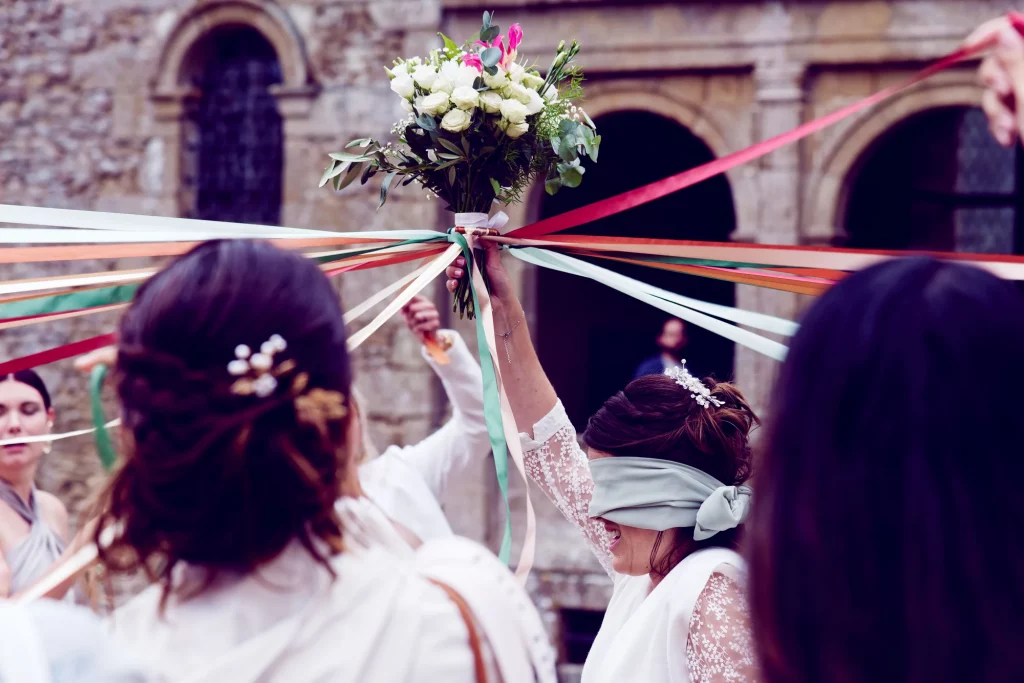 Mariée aux yeux bandés avec son bouquet pour le jeu du ruban à Saint-Hilaire-du-Harcouët.