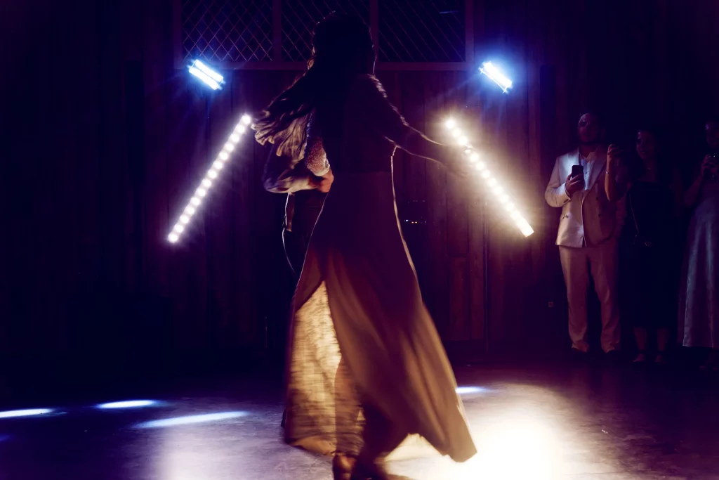 Mariée dansant, robe en mouvement sous des projecteurs LED lors d'une soirée à Saint-Hilaire-du-Harcouët.