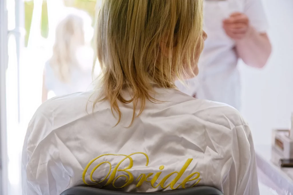 Mariée de dos en peignoir satiné Bride à Saint-Hilaire-du-Harcouët, Normandie.