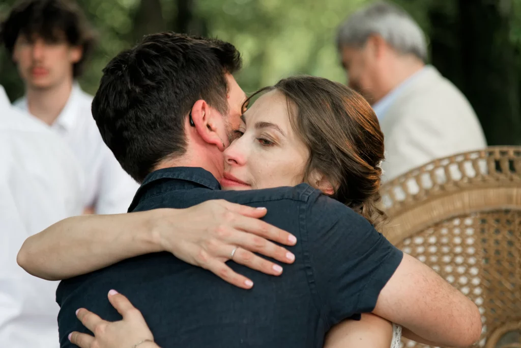 Mariée émue aux larmes enlaçant son époux lors d'un mariage à Saint-Hilaire-du-Harcouët, Normandie.