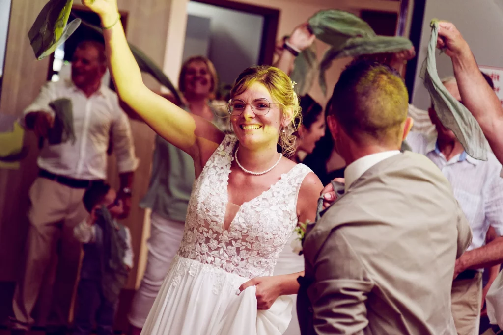 Mariée souriante dansant avec ses invités à Saint-Hilaire-du-Harcouët, Normandie.