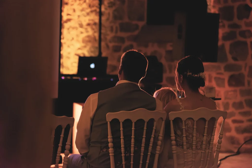 Mariés et enfant de dos regardant une projection, mariage Normandie à Saint-Hilaire-du-Harcouët.
