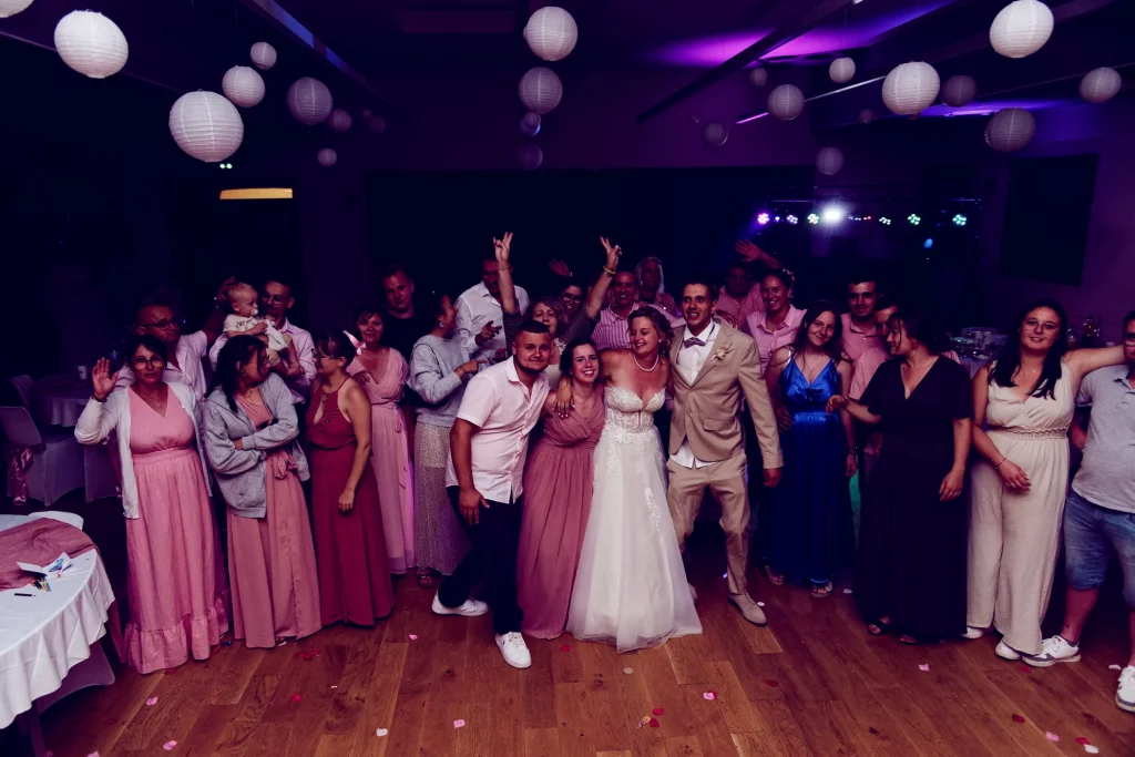Mariés et invités sur la piste de danse sous des lanternes à Saint-Hilaire-du-Harcouët, Normandie.