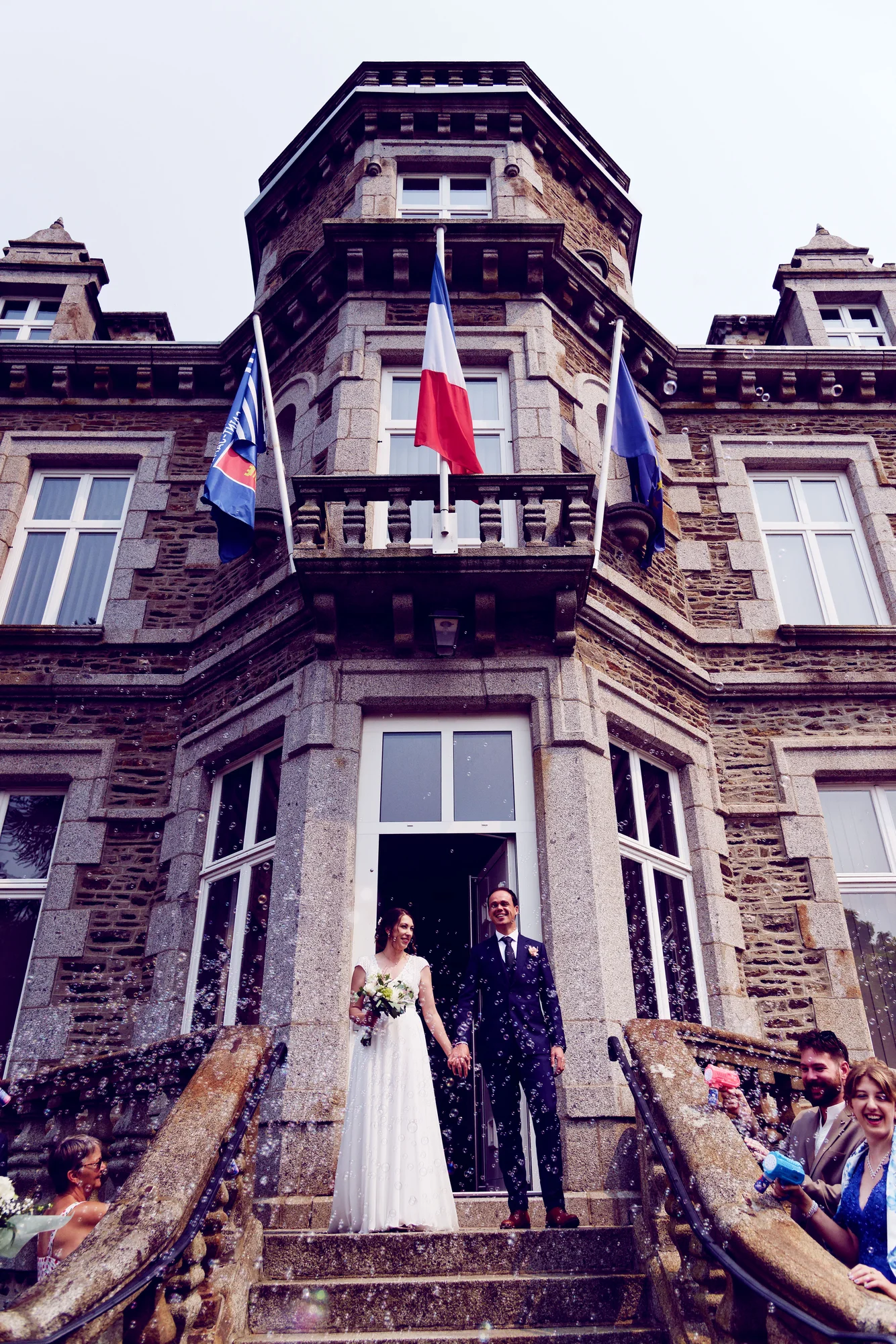 Mariés sortant de la mairie de Saint-Hilaire-du-Harcouët sous une pluie de bulles, Normandie.