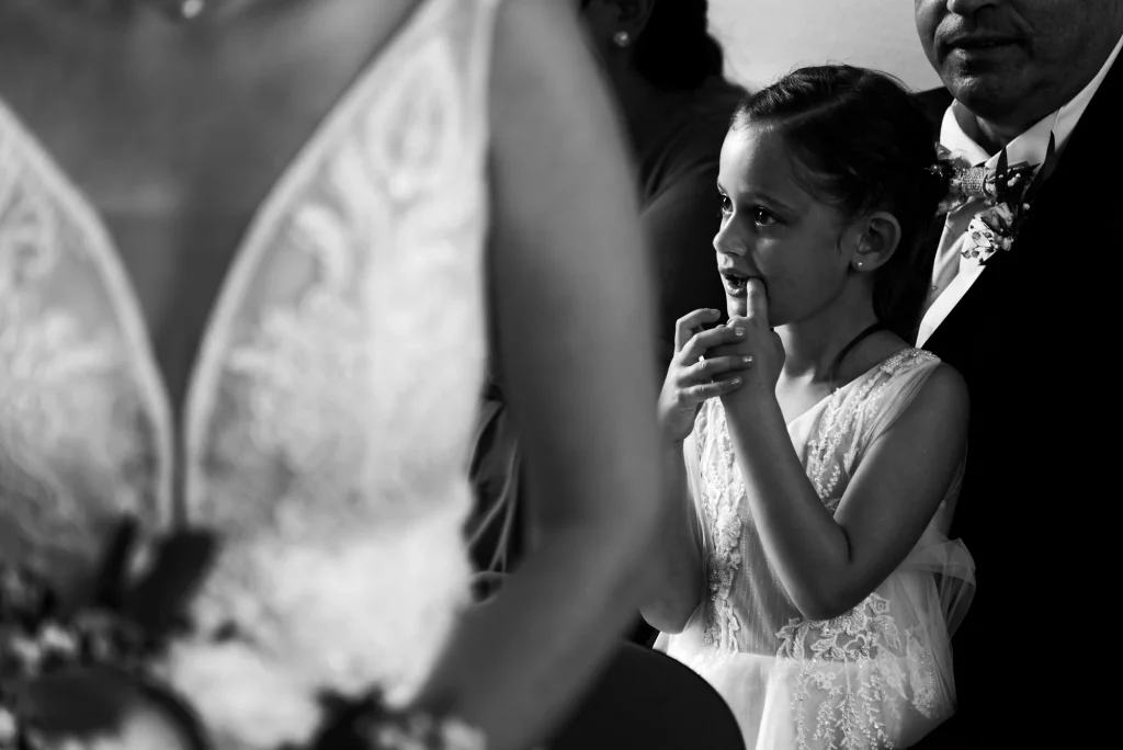 Petite fille d'honneur admirant la mariée lors d'un mariage en Normandie.
