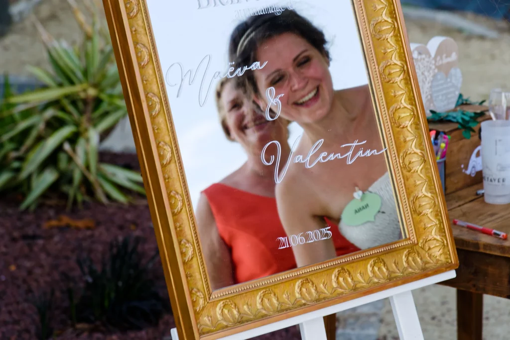 Reflet dans un cadre doré de la mariée et de sa sœur partageant un rire complice