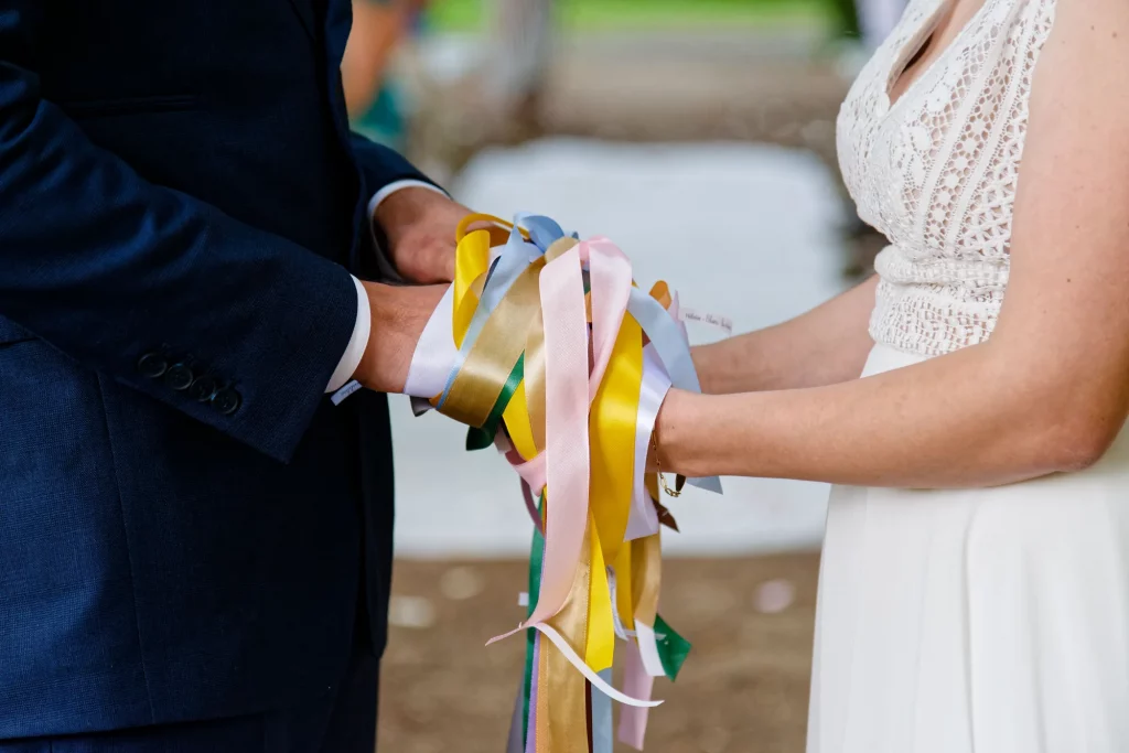 Rituel des rubans lors d'une cérémonie laïque en Normandie : mains liées des mariés à Saint-Hilaire-du-Harcouët.