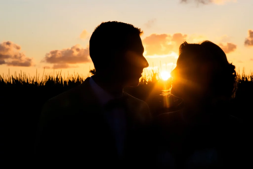 Silhouette d'un couple de mariés au coucher du soleil à Saint-Hilaire-du-Harcouët en Normandie.