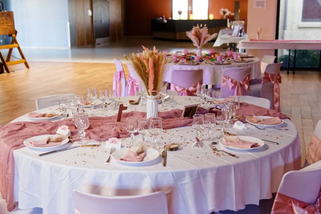 Table de mariage avec chemin de table rose et fleurs séchées à Saint-Hilaire-du-Harcouët.
